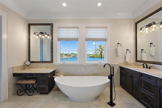 bathroom with vanity, a bath, a water view, and tile walls