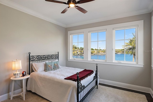 bedroom featuring ornamental molding, a water view, and ceiling fan