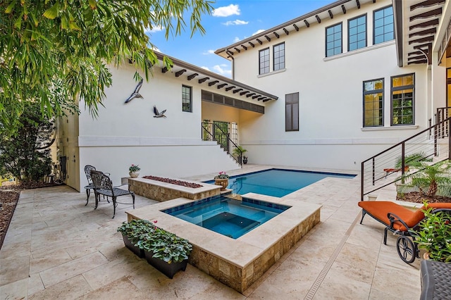 view of swimming pool featuring a patio and an in ground hot tub