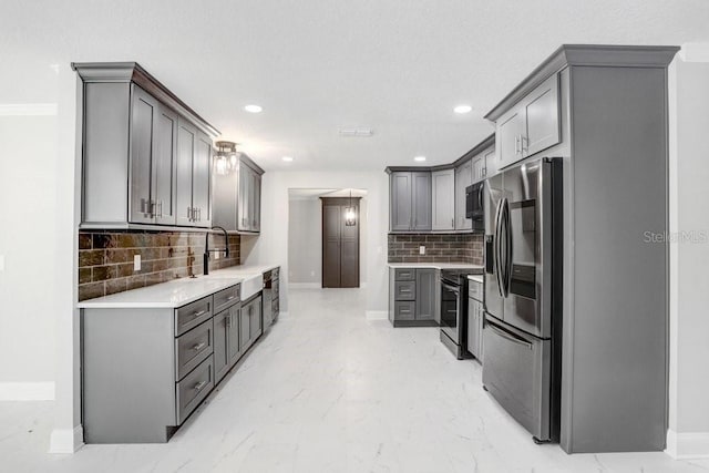 kitchen featuring gray cabinetry, sink, decorative backsplash, and stainless steel appliances