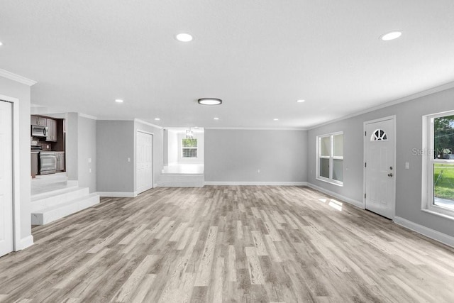 unfurnished living room with a wealth of natural light, light hardwood / wood-style flooring, and crown molding