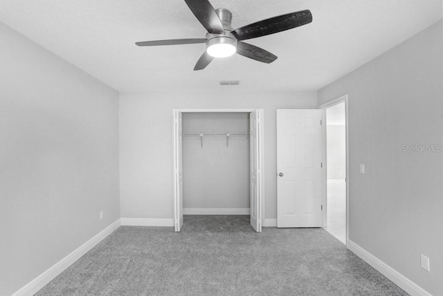 unfurnished bedroom featuring ceiling fan, light carpet, and a closet