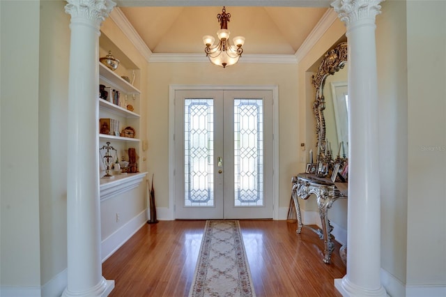 foyer featuring vaulted ceiling, french doors, and ornate columns