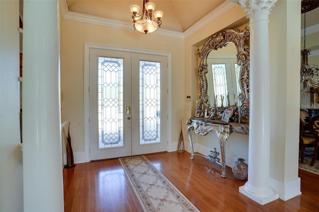 foyer entrance with a notable chandelier, hardwood / wood-style flooring, decorative columns, and french doors