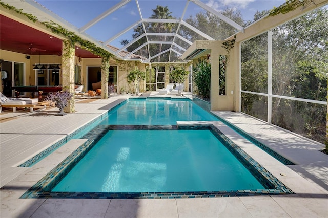 view of swimming pool with an in ground hot tub, a patio, ceiling fan, and glass enclosure