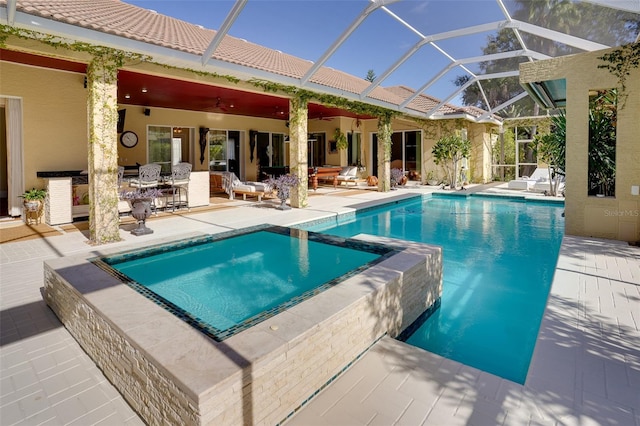 view of swimming pool with a patio, a lanai, and an in ground hot tub