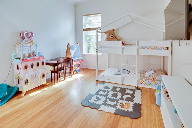 bedroom with multiple windows, hardwood / wood-style floors, and crown molding