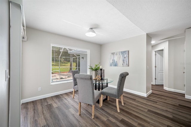 dining area featuring dark hardwood / wood-style floors and a textured ceiling