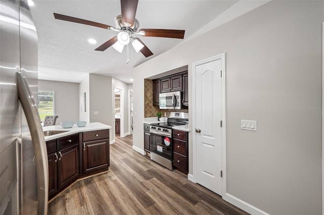 kitchen featuring dark wood-type flooring, dark brown cabinetry, stainless steel appliances, and tasteful backsplash