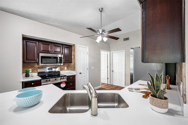 kitchen with tasteful backsplash, sink, ceiling fan, stainless steel appliances, and hardwood / wood-style flooring