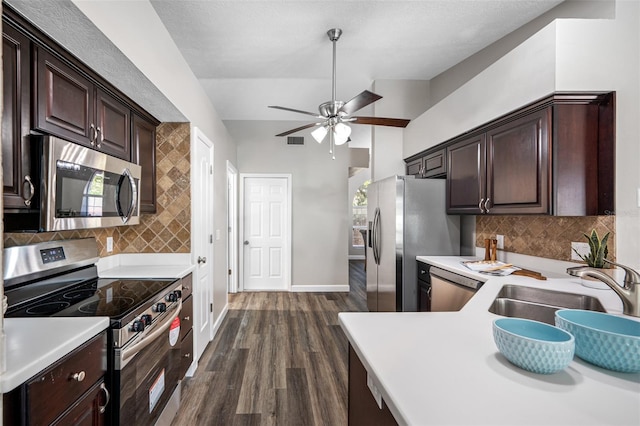 kitchen with dark hardwood / wood-style floors, sink, tasteful backsplash, appliances with stainless steel finishes, and ceiling fan