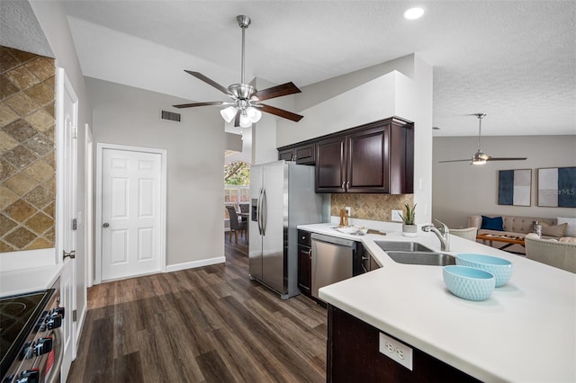 kitchen with dark wood-type flooring, stainless steel appliances, sink, dark brown cabinetry, and a textured ceiling