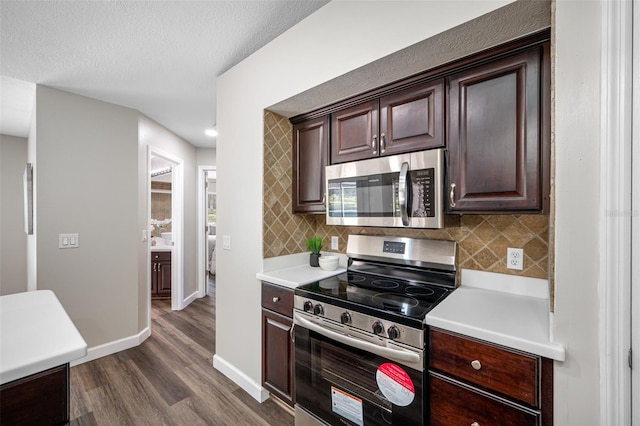 kitchen with appliances with stainless steel finishes, a textured ceiling, dark brown cabinetry, and dark wood-type flooring