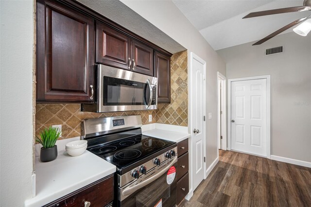 kitchen with lofted ceiling, appliances with stainless steel finishes, tasteful backsplash, and dark hardwood / wood-style flooring