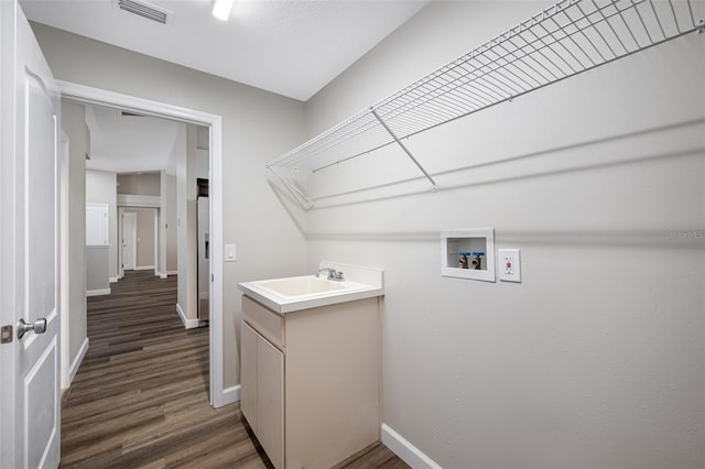 laundry area with hookup for a washing machine, sink, and dark hardwood / wood-style flooring