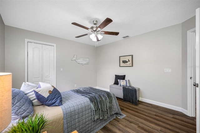 bedroom featuring a closet, a textured ceiling, ceiling fan, and dark hardwood / wood-style flooring