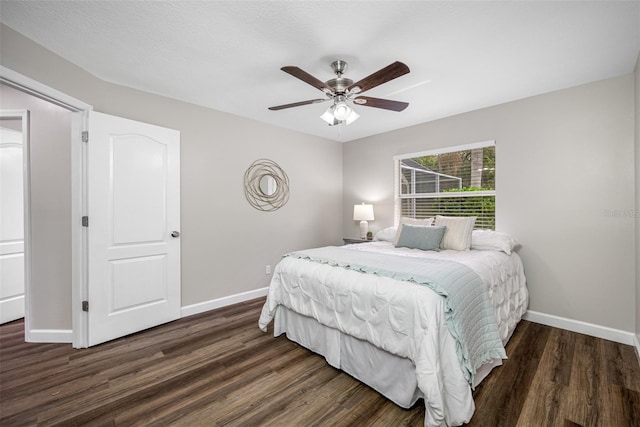 bedroom with dark wood-type flooring, a textured ceiling, and ceiling fan