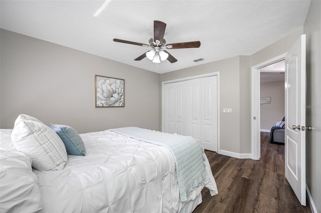 bedroom with a closet, dark hardwood / wood-style floors, a textured ceiling, and ceiling fan