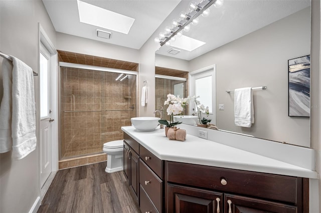 bathroom with vanity, toilet, hardwood / wood-style flooring, and a shower with shower door