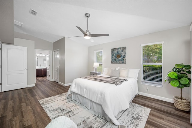 bedroom with connected bathroom, ceiling fan, multiple windows, and dark hardwood / wood-style floors