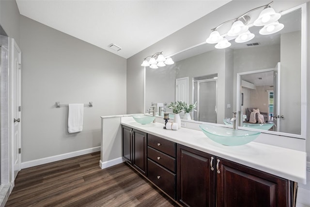 bathroom featuring vanity, lofted ceiling, wood-type flooring, and walk in shower