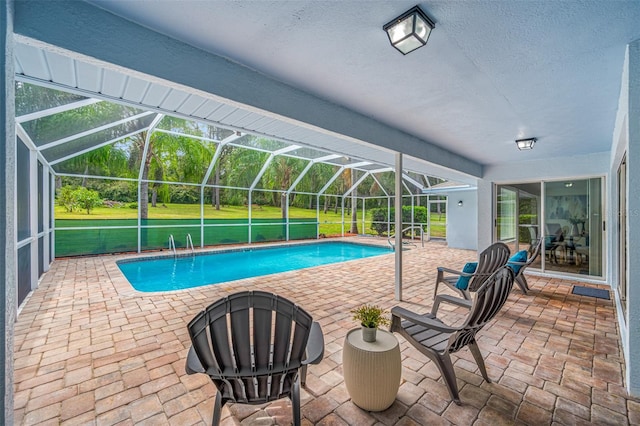 view of pool with a yard, a patio area, and a lanai