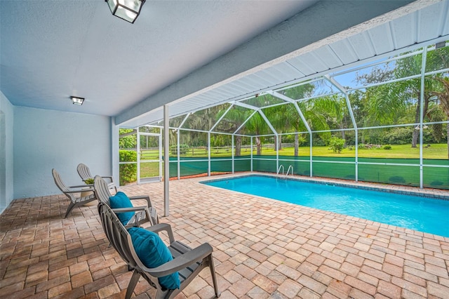 view of swimming pool with a patio area and a lanai