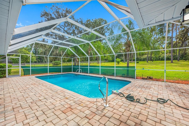 view of swimming pool featuring a patio area, a lawn, and glass enclosure