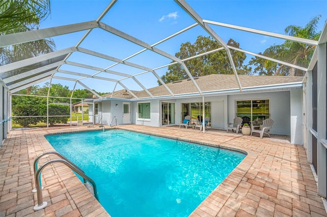 view of swimming pool with a patio area and glass enclosure