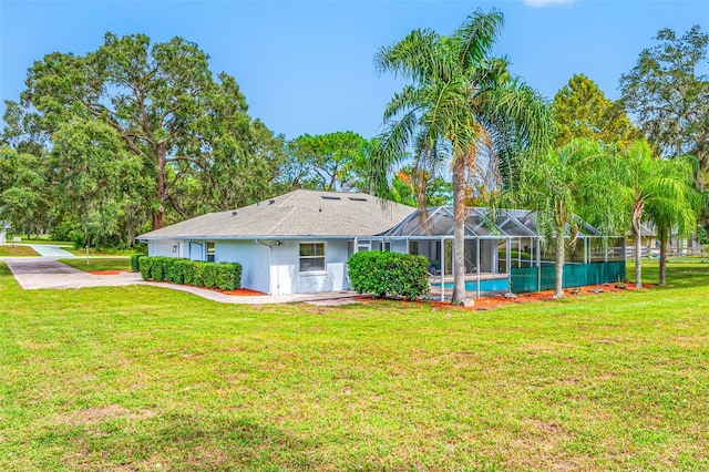 rear view of property featuring a patio area, a lanai, and a yard