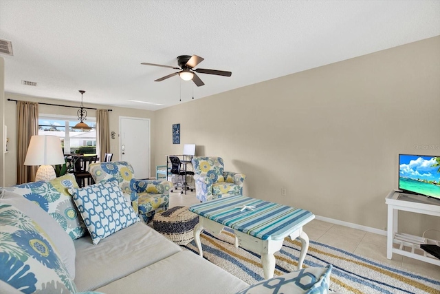 tiled living room featuring ceiling fan and a textured ceiling