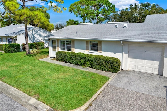 single story home featuring a front lawn and a garage