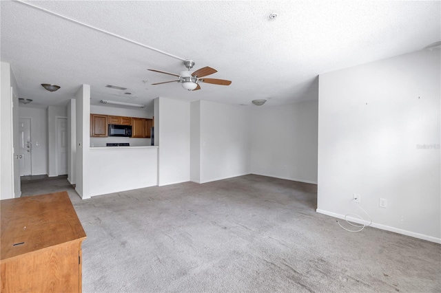 unfurnished living room with ceiling fan, a textured ceiling, and carpet