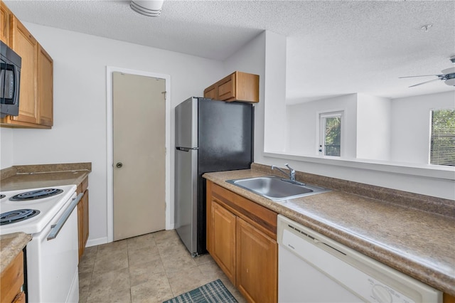 kitchen featuring a textured ceiling, sink, appliances with stainless steel finishes, light tile patterned floors, and ceiling fan