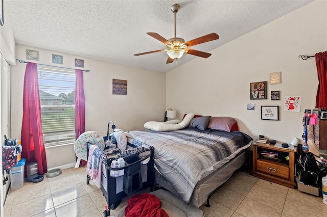 bedroom with light tile patterned flooring, a textured ceiling, and ceiling fan