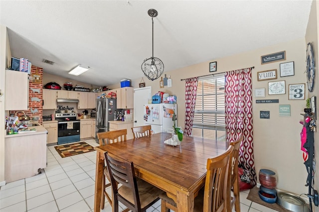 tiled dining area with an inviting chandelier, lofted ceiling, and sink