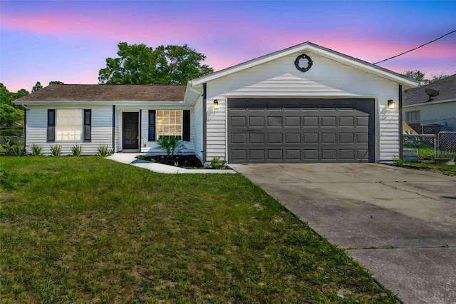 single story home with driveway, a garage, fence, and a lawn