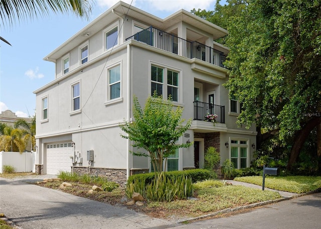 view of front of property featuring a balcony and a garage