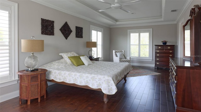 bedroom with ceiling fan, a raised ceiling, dark wood-type flooring, and crown molding