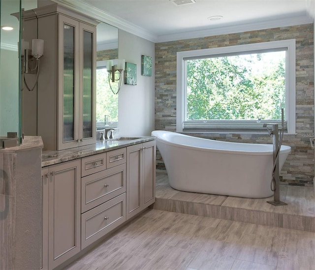 bathroom with vanity, a bathtub, tile walls, crown molding, and hardwood / wood-style floors