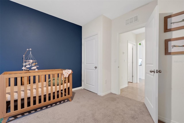 bedroom featuring a notable chandelier, a crib, and light carpet