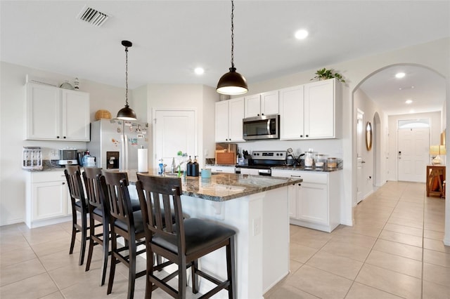 kitchen with white cabinets, a kitchen island, and stainless steel appliances