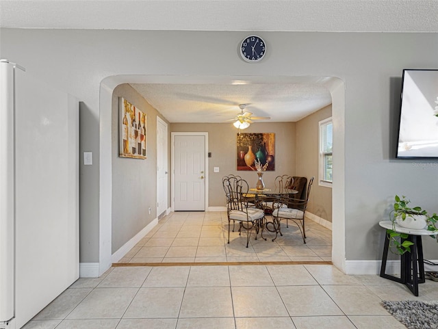 tiled dining area featuring ceiling fan and a textured ceiling