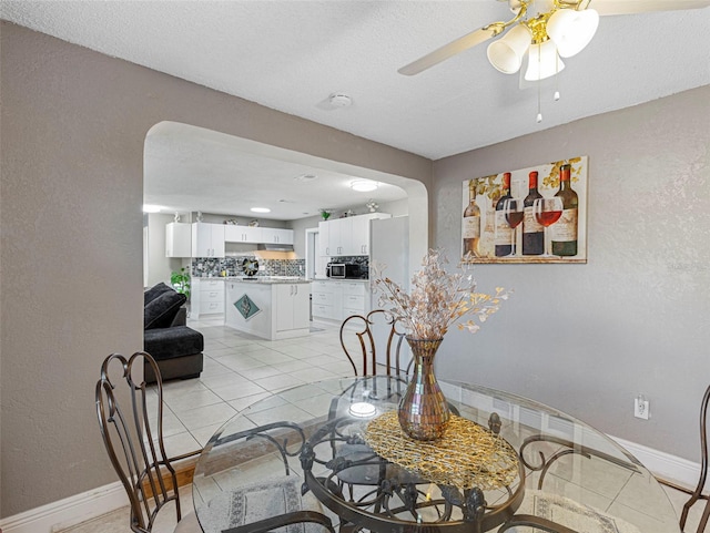 dining room with ceiling fan, light tile patterned floors, and a textured ceiling