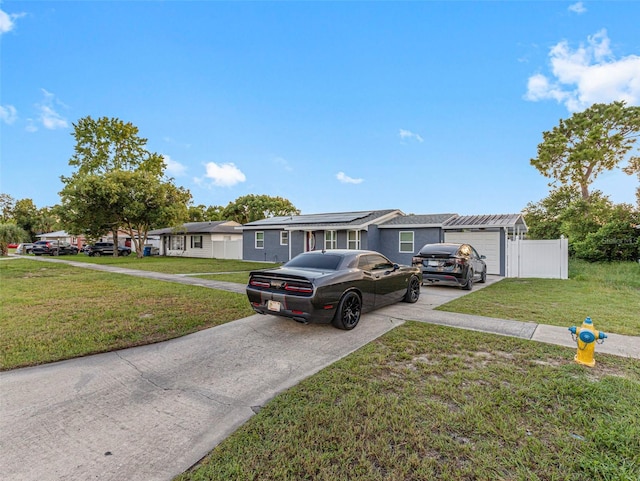 ranch-style house featuring concrete driveway, a front yard, a residential view, and an attached garage