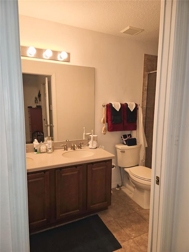 bathroom with toilet, tile patterned floors, an enclosed shower, a textured ceiling, and vanity