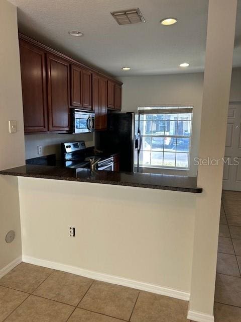 kitchen featuring tile patterned floors, kitchen peninsula, and appliances with stainless steel finishes