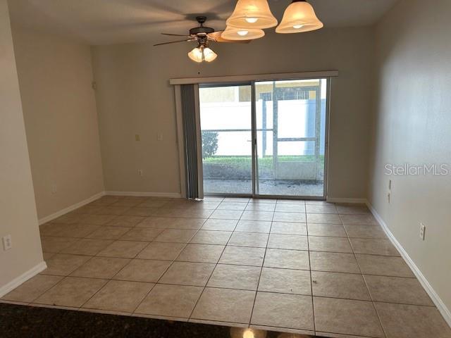 tiled empty room featuring ceiling fan