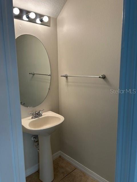 bathroom with tile patterned flooring and a textured ceiling