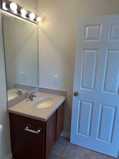 bathroom featuring vanity, tile patterned flooring, and toilet